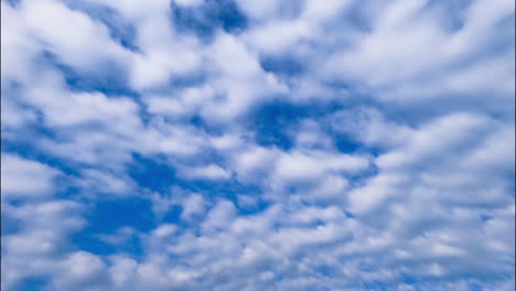 cirrocumulus clouds slowly spreading along the horizon. amazing azure sky is behind the cloudscape. timelapse.