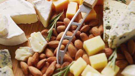 video of diverse cheeses and nuts lying on wooden board