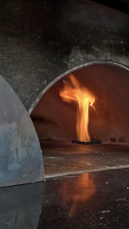 fire flickers within a traditional pizza oven.