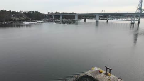drone flight over tug boat towards bridge, winter scene with snow, kennebec river, bath, me.