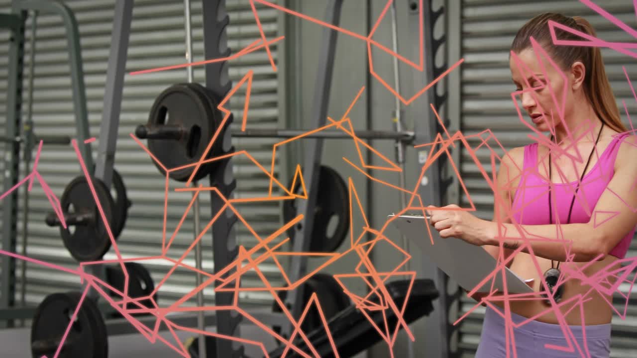 Entrenador tocando el portapapeles que causa un desvanecimiento de la superposición, comprobando la sesión de seguimiento del silbato en el gimnasio junto al rack