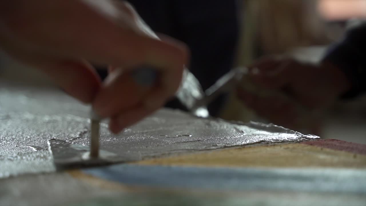 Team Working With Trowel Spreading Cement Over Flat Element