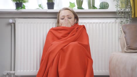 de vrouw die op de kachel leunt, heeft het koud.