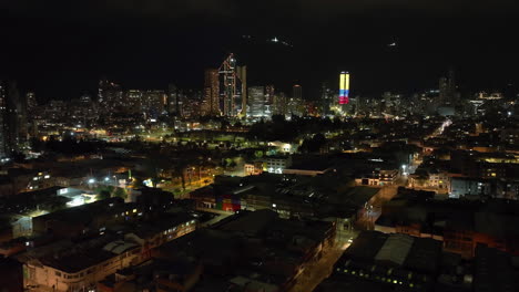 aerial flyover shot over the illuminated bogota cityscape, night in colombia