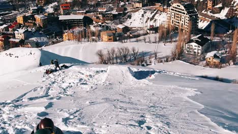 slow motion, drone shot, wide: pro snowboarders getting ready at the top of the slope. camera flying over slope