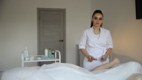 woman getting a leg massage with bamboo tools.