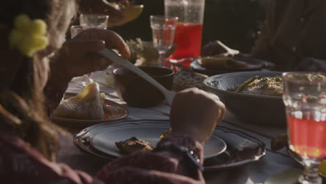 people eating and drinking at an outdoor dinner party