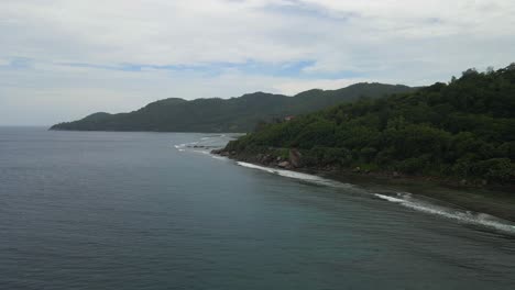landscapes in seychelles showing the nature, maountains, ocean, sea, and massive granit rocks filmed from above with a drone in 4k with movement