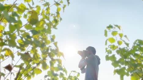 man using dslr professional camera outdoor, sunny bright day, slow motion