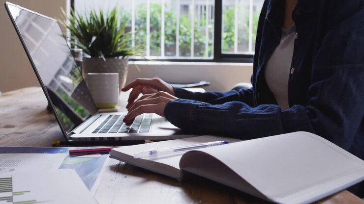 Mid section of woman using laptop at home