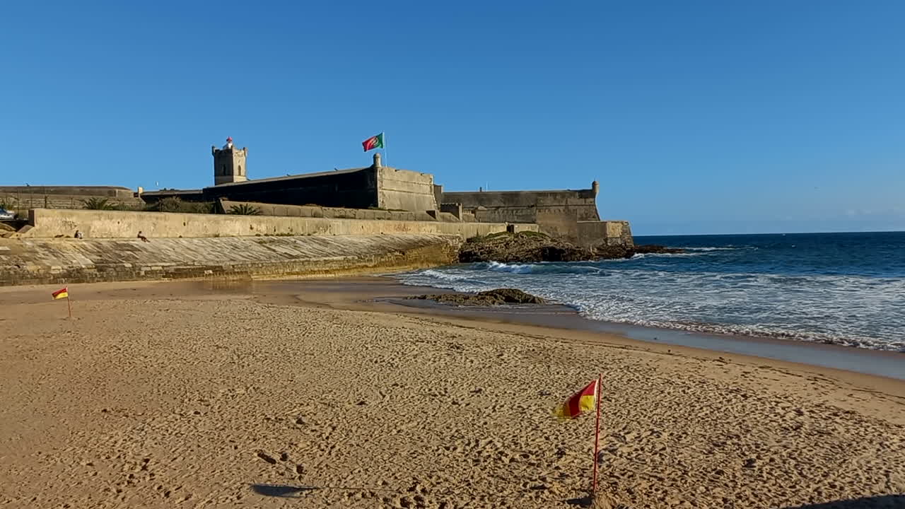 la playa de carcavelos con la fortaleza de são julião da barra, el complejo de defensa militar más grande y completo en el estilo vauban que queda en portugal.