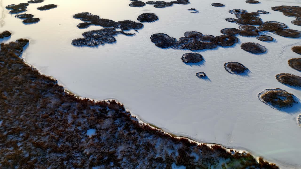 vista aerea di un lago ghiacciato con diverse isole che sporgono dal ghiaccio