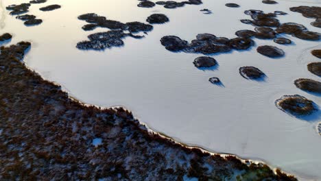 aerial view of a frozen lake with several islands jutting out of the ice