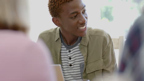 Happy-diverse-group-of-teenage-friends-studying-at-table-with-tablets-at-home,-slow-motion