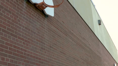 Basketball-hoops-on-a-red-brick-wall-of-a-schoolyard