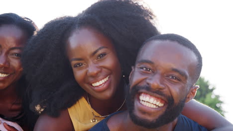 two black couples, men piggybacking their partners, close up