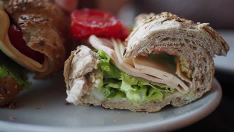un primer plano de un sándwich de pavo y queso en una baguette de trigo entero