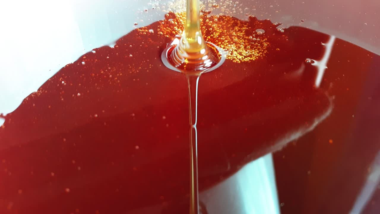 Honey pourin in white bowl