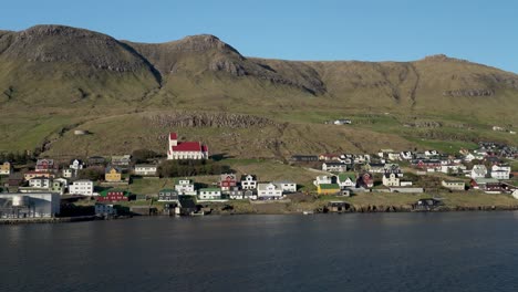 pov wide shot of tvoroyri village on suduroy island during beautiful day in summer, faroe island