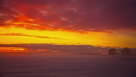 time lapse shot of yellow sunset over foggy landscape with flying clouds in nature