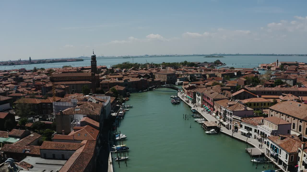 Aerial view pulling away from Murano, Italy's waterways interconnecting the city