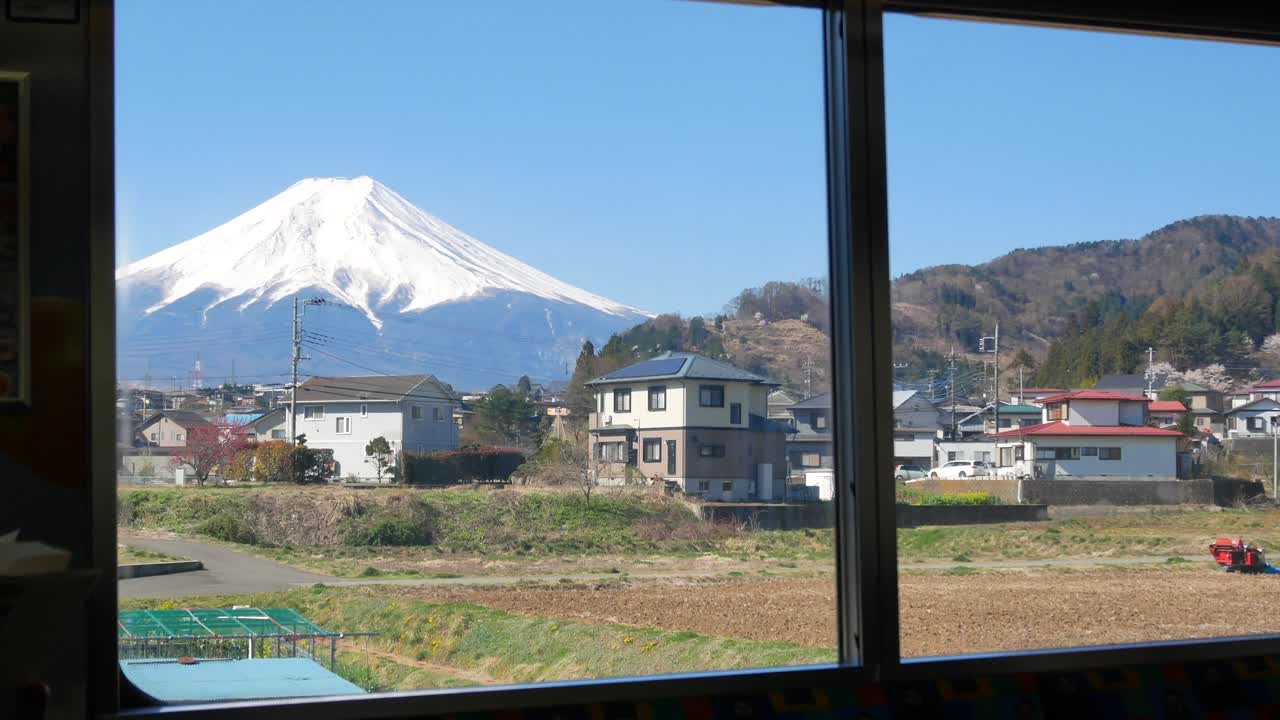 vista del paisaje natural de la montaña volcánica fuji desde el interior del tren local mientras se mueve en el día de primavera-4k uhd video filmación corta