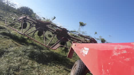 esparcidor de hierba de elevación del vehículo agrícola - bajada en el campo de hierba