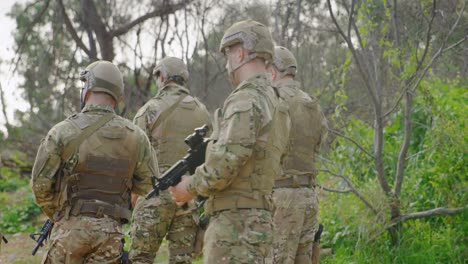 Vista-Trasera-De-Soldados-Militares-De-Raza-Mixta-Entrenando-Con-Rifles-En-Campos-Durante-El-Entrenamiento-Militar-4k