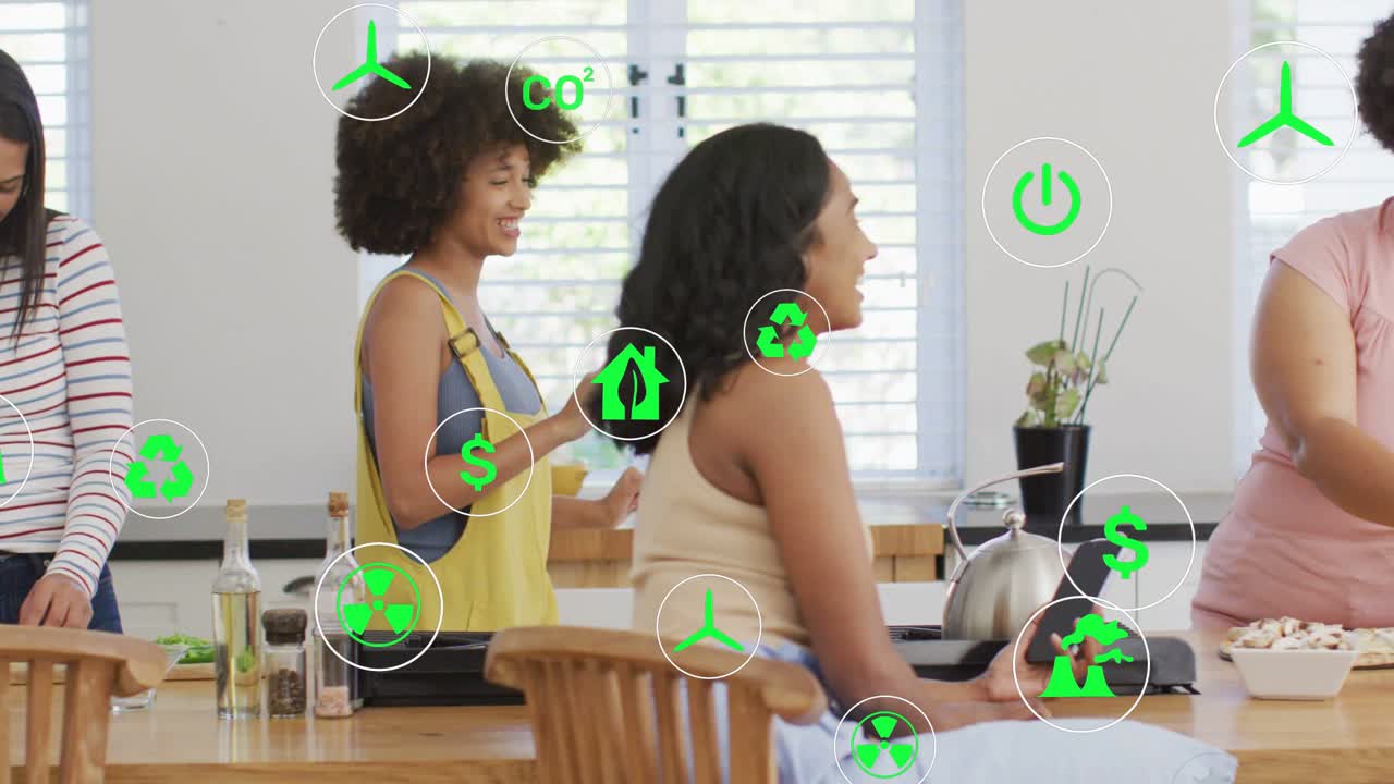 Tres mujeres preparando en la isla de la cocina, una mujer gesticulando con una tablet inicia iconos verdes que guían la cocina.