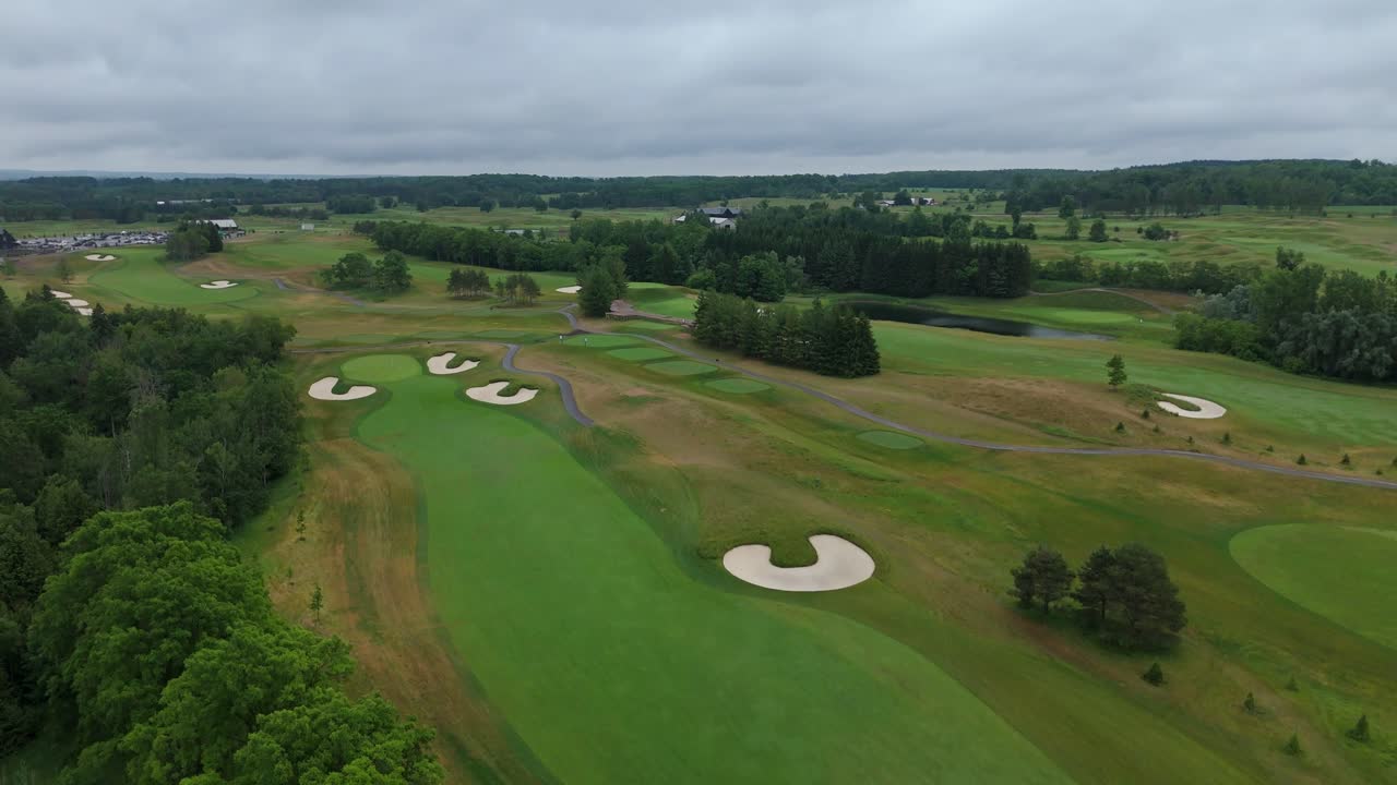 Luftaufnahme mit einer Drohne über TPC Toronto im Osprey Valley mit gewundenen Fairways, Bunkern und Teichen unter einem dramatischen, bewölkten Himmel in Alton, Caledon, Ontario, Kanada
