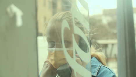 Woman-in-mask-speaking-on-telephone-on-street