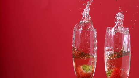 strawberries falling into champagne flutes