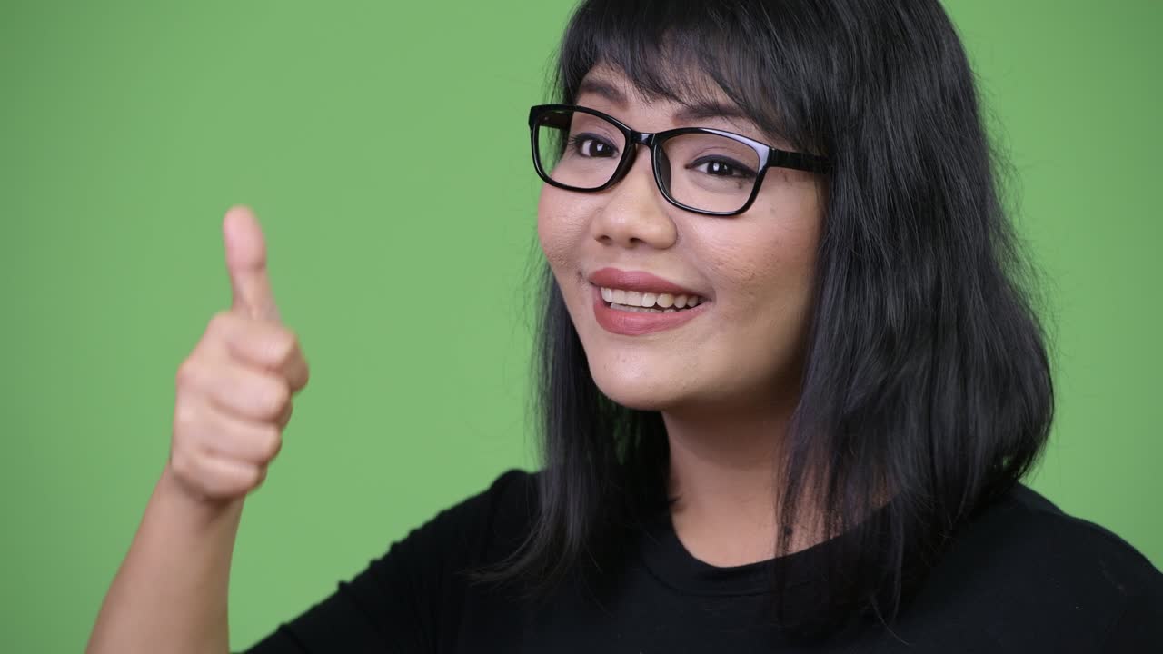 Beautiful Asian businesswoman giving thumbs up