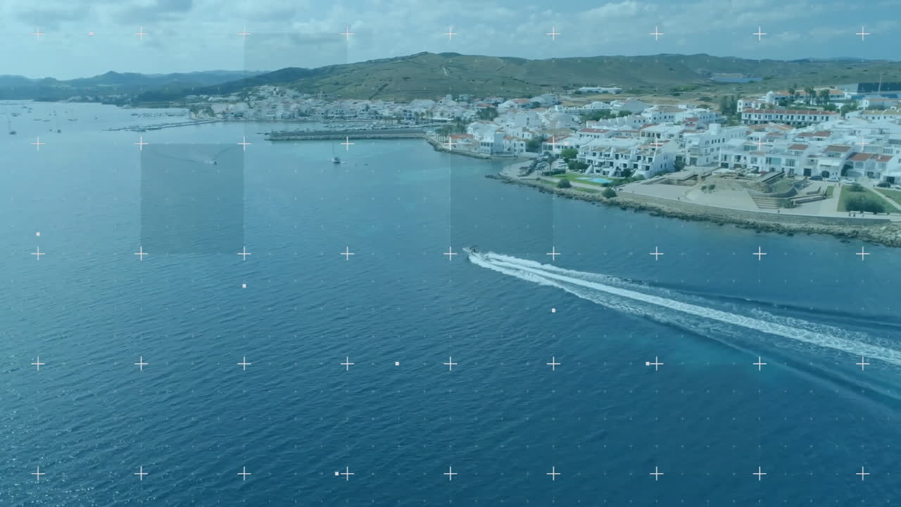 Speedboat cutting through deep blue sea, leaving white wake, revealing white coastal buildings