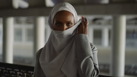 african-american lady raises up hijab to hide face on street