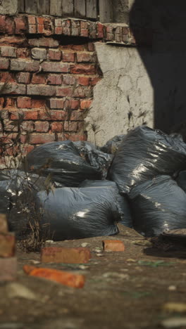 pile of garbage bags near a brick wall