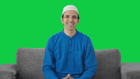 hombre musulmán feliz haciendo adaab y saludando pantalla verde