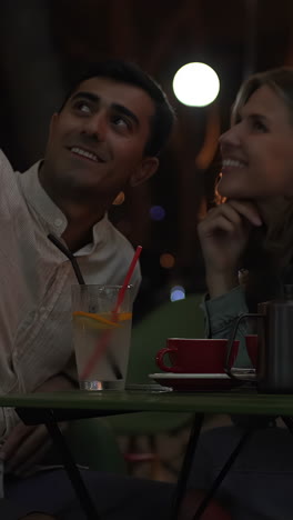 couple enjoying drinks at a night cafe