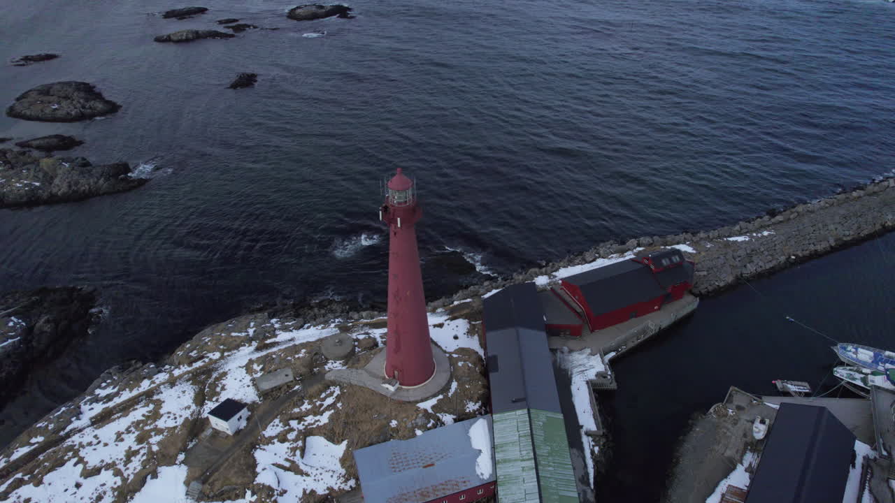 사람들이 위에 있고 눈이 땅에 있는 안데네 등대를 공전하는 공중 하향 전망
