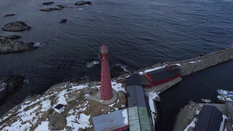 vista aérea hacia abajo orbitando el faro de andenes con gente en la parte superior y nieve en el suelo