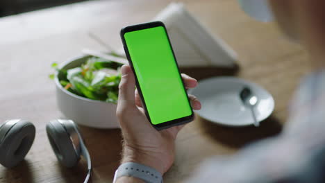 cerca manos de un hombre de negocios usando un teléfono inteligente en un café viendo la pantalla verde en el teléfono móvil chroma clave disfrutando del entretenimiento en línea bebiendo café leyendo publicidad en las redes sociales