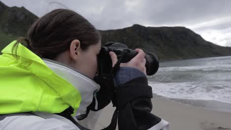 Mujer-Morena-Fotografiando-El-Océano-Y-Las-Montañas-Durante-El-Día-Nublado,-Cierra-A-Cámara-Lenta