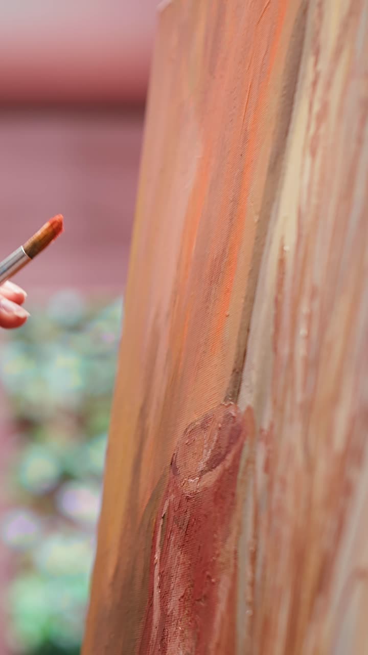 Artist's Hand Painting on Canvas with a Brush