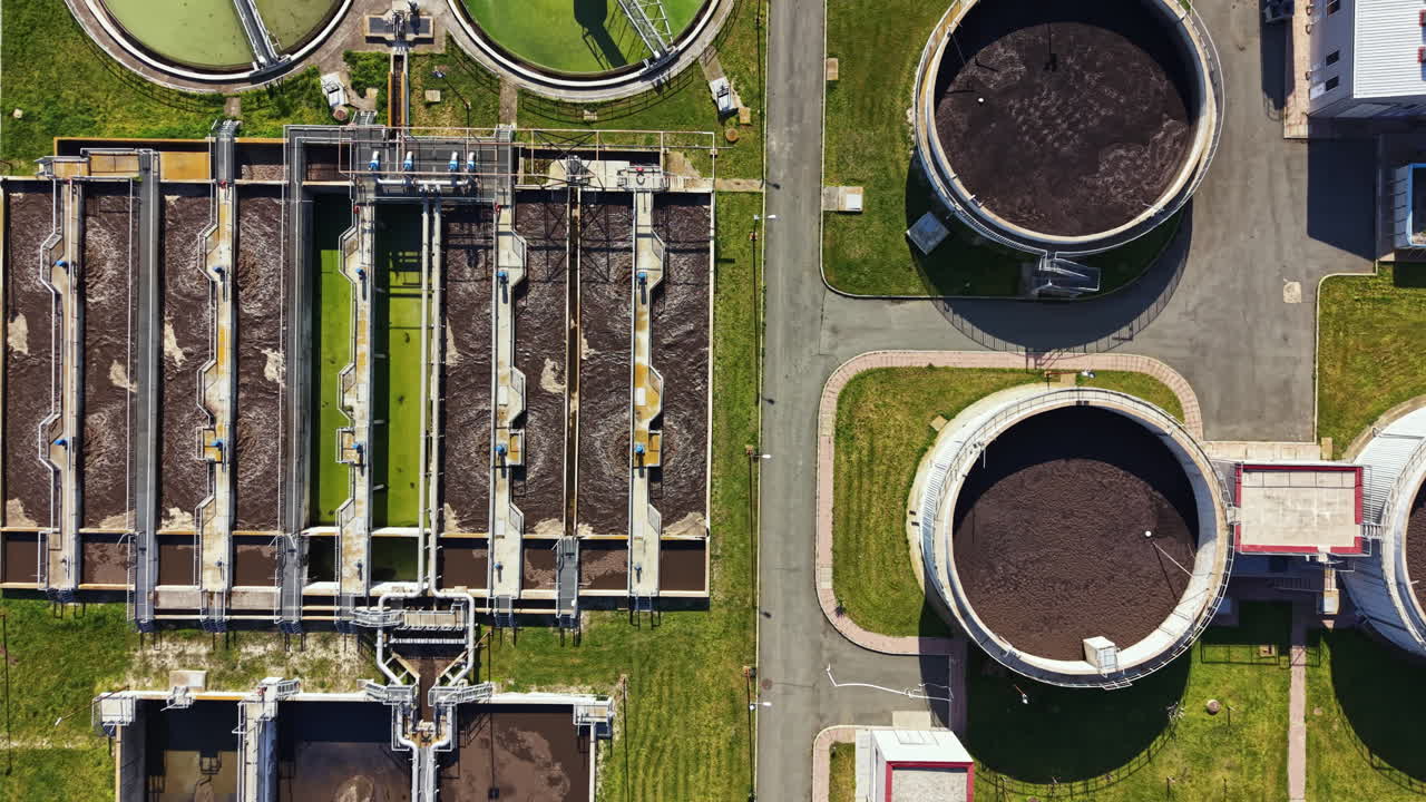 Water treatment facility shows various tanks and machinery working together to treat wastewater efficiently at a busy industrial site