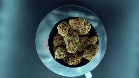 a cinematic top down detailed smooth crane movement shot of a cannabis plant, hybrid orange strains, indica type, marijuana flower, slow motion 120 fps, studio led lights, shiny rotating stand