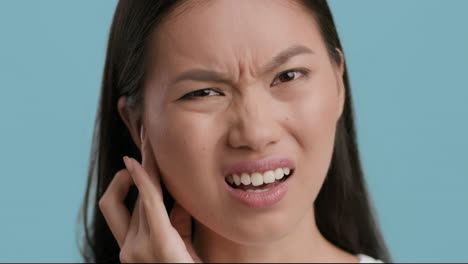 young asian woman suffering from ear pain or jaw discomfort