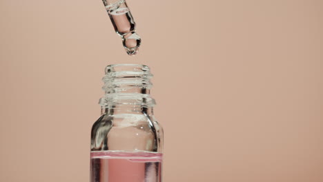 botella de gotero con líquido rosado