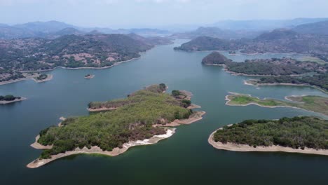 Rotating-aerial-over-sprawling-low-water-Cerron-Grande-Reservoir,-SLV