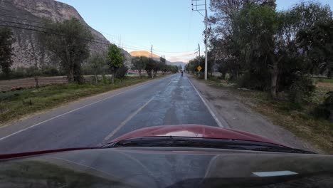 Red-car,-front-view,-Driving-on-the-highway-to-Urubamba,-from-Yucay-to-Urubamba,-Sacred-Valley