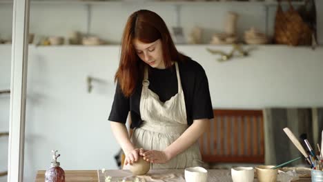 girl potter forms her product on the board